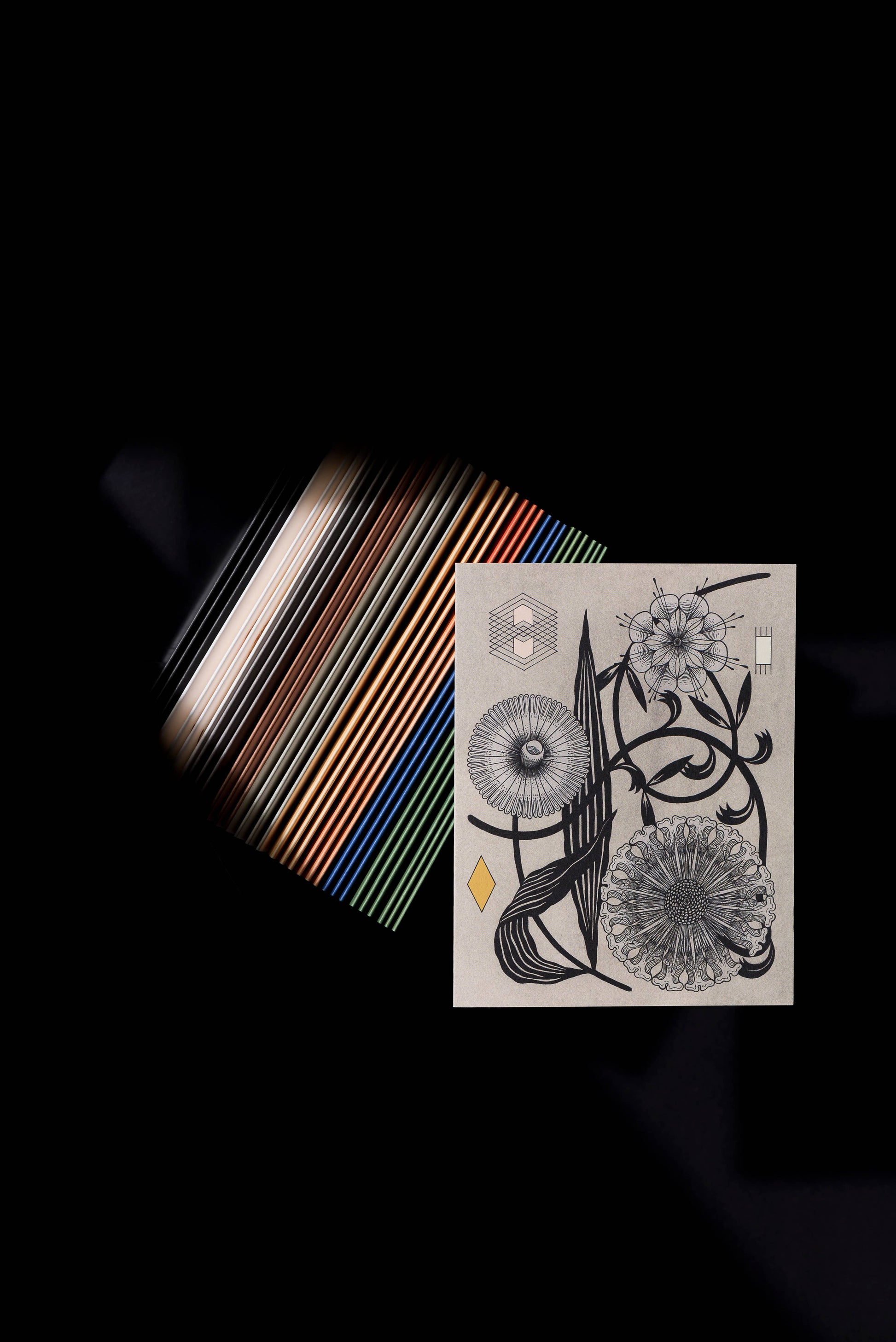 Stylized photo over a textured background, of a gray card with geometric symbols and flowers on it