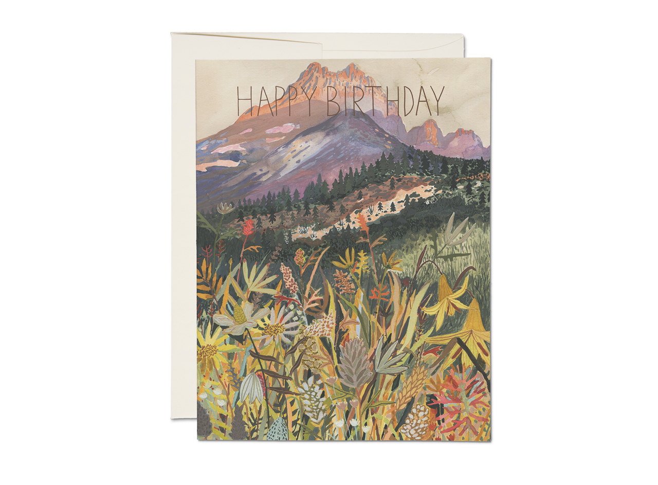 Greeting card with mountain and nature design and 'Happy Birthday' text.