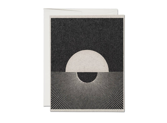 Greeting card with a minimalist ink design of a moon and sun on a textured white  background